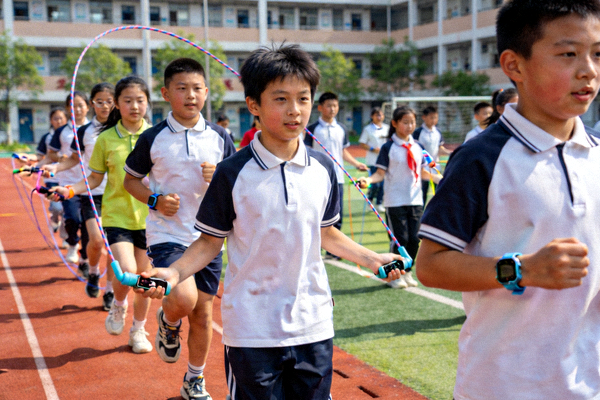 学校体育课堂，学生使用智能设备进行体育锻炼